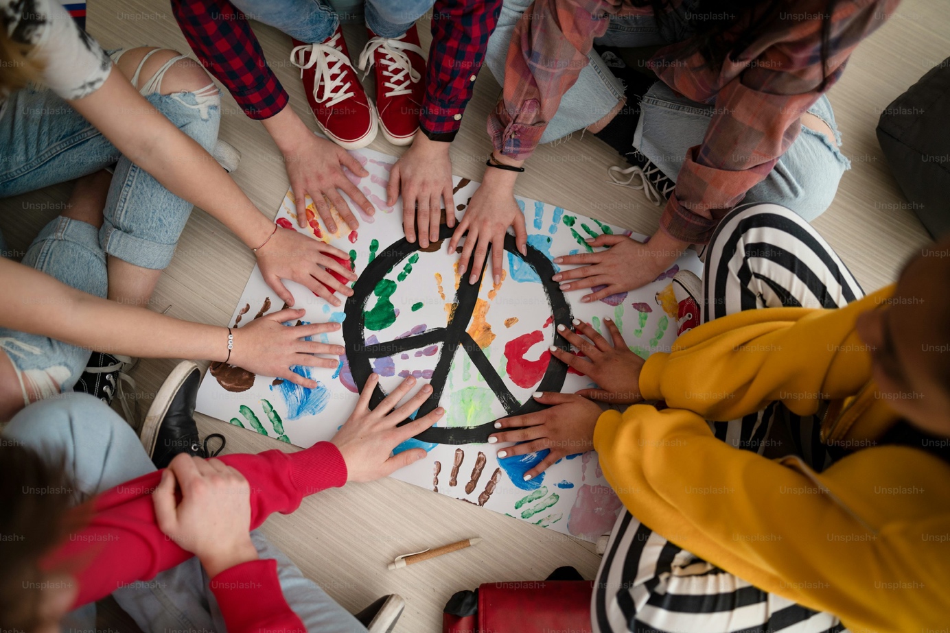 Schülerinnen und Schüler gestalten gemeinsam ein Friedenszeichen
